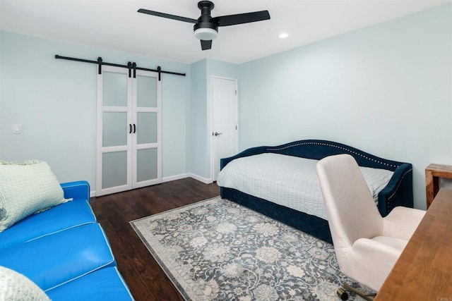 bedroom with a barn door, baseboards, a ceiling fan, wood finished floors, and recessed lighting