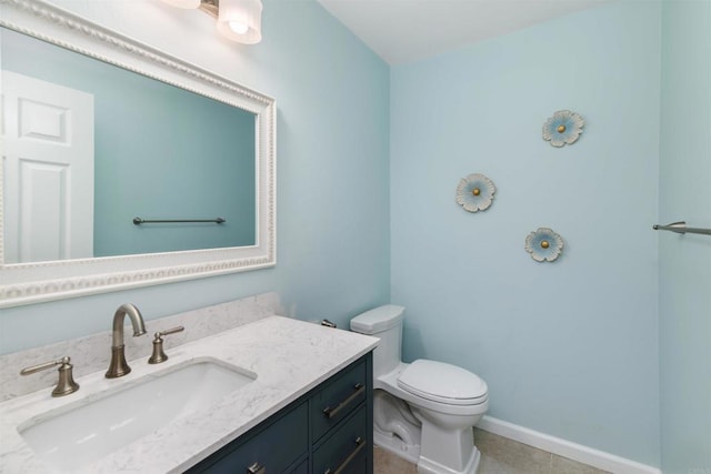 bathroom with tile patterned flooring, vanity, toilet, and baseboards