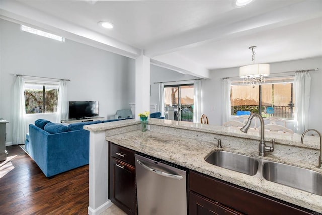 kitchen featuring stainless steel dishwasher, dark wood-type flooring, open floor plan, a sink, and light stone countertops