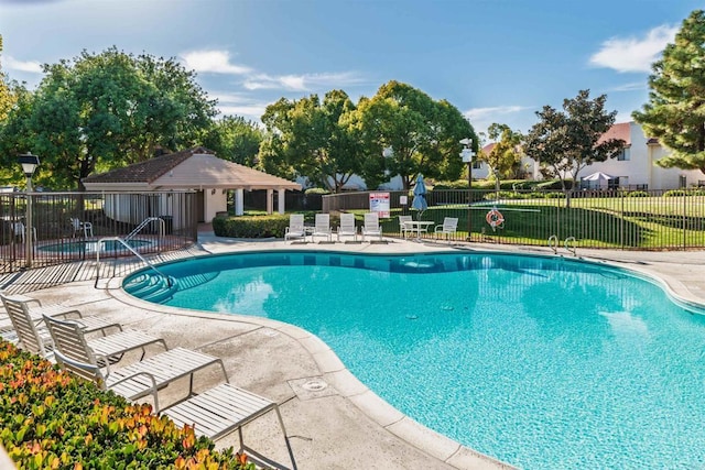 pool with a yard, fence, and a patio