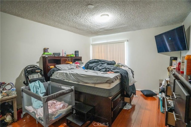 bedroom featuring a textured ceiling and hardwood / wood-style floors