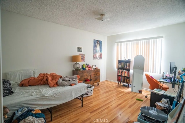 bedroom featuring light wood-type flooring and a textured ceiling