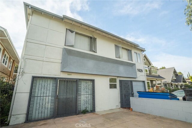 back of property featuring fence and stucco siding