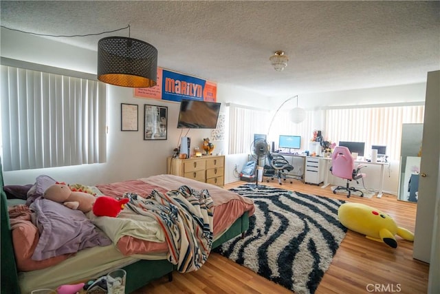 bedroom featuring a textured ceiling and wood finished floors