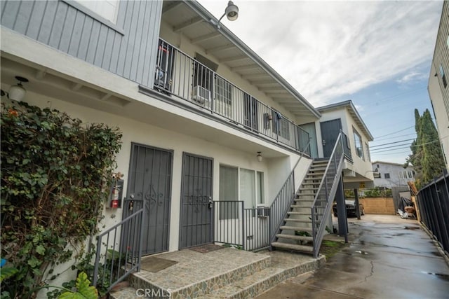 exterior space featuring a patio area, fence, and stucco siding