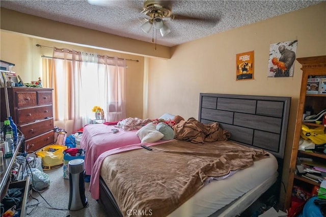 carpeted bedroom featuring a ceiling fan and a textured ceiling