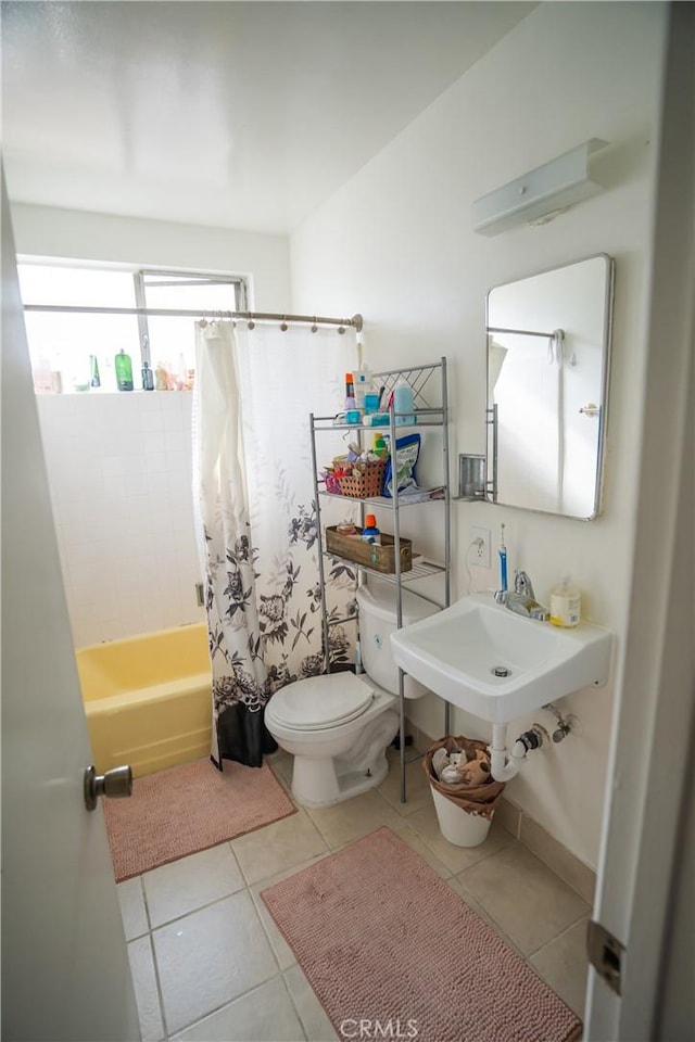 full bath featuring a sink, shower / bath combo with shower curtain, toilet, and tile patterned floors