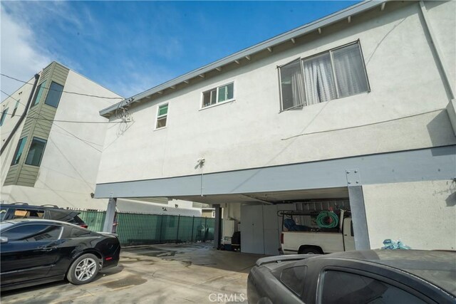 exterior space with stucco siding and fence
