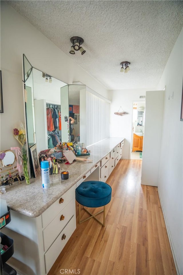 bathroom with a textured ceiling and wood finished floors