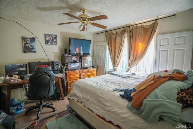 carpeted bedroom featuring a textured ceiling and ceiling fan