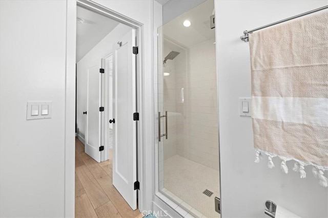 bathroom featuring a shower stall and wood finished floors