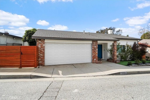 view of front facade featuring brick siding, roof with shingles, concrete driveway, an attached garage, and a gate