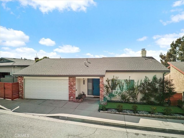 view of front of property featuring a garage, a chimney, fence, and concrete driveway