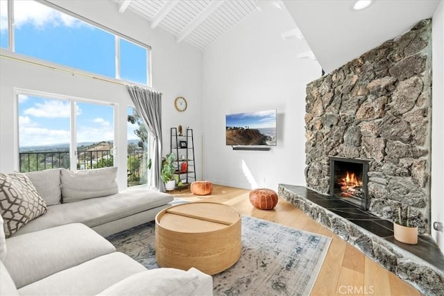 living area with wood ceiling, wood finished floors, a fireplace, high vaulted ceiling, and beam ceiling