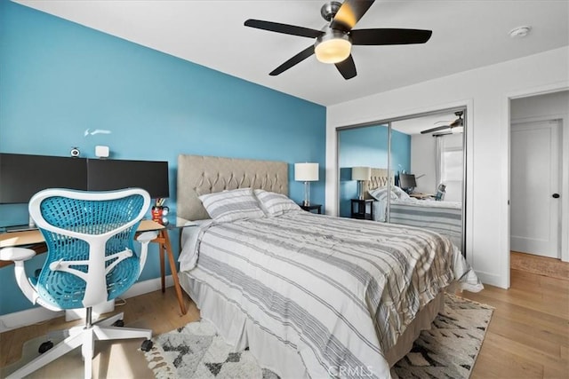 bedroom with baseboards, a closet, a ceiling fan, and wood finished floors