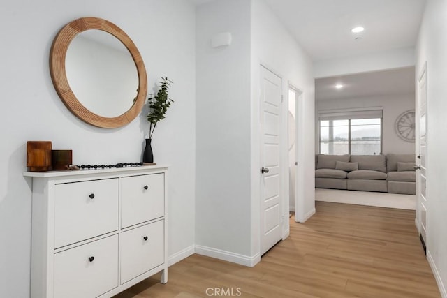 hall featuring recessed lighting, light wood-type flooring, and baseboards