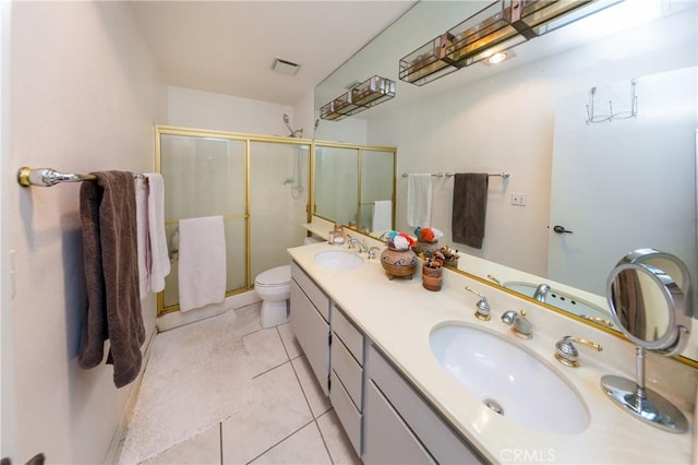 bathroom with double vanity, visible vents, a stall shower, a sink, and tile patterned floors