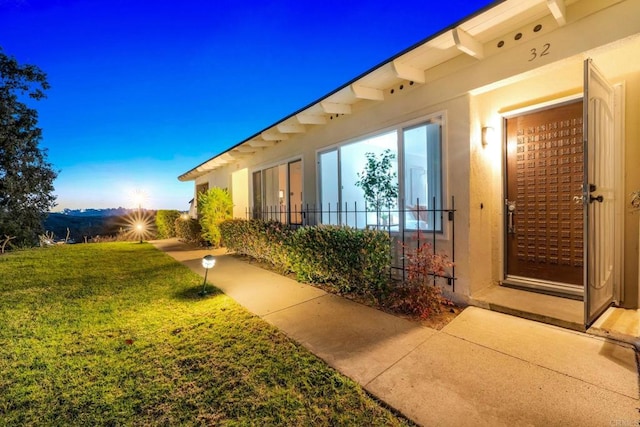 3839 Vista Campana S Unit 32, Oceanside, CA 92057 - view of exterior entry featuring a yard and stucco siding