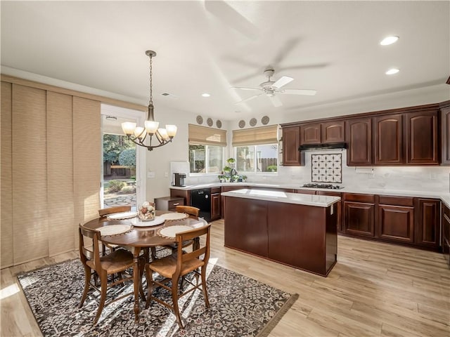 kitchen featuring a center island, gas stovetop, tasteful backsplash, light countertops, and light wood-style flooring