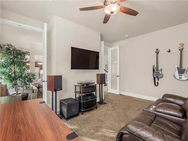 carpeted living area with french doors, a ceiling fan, and baseboards