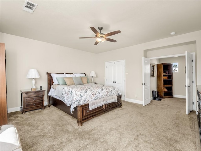 bedroom featuring a ceiling fan, visible vents, light carpet, and baseboards