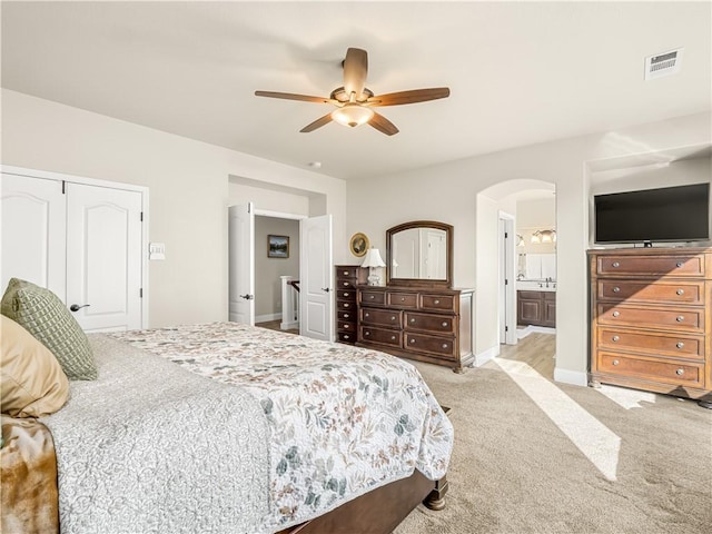 2705 E Ryan Ln, Fresno, CA 93720 - carpeted bedroom featuring arched walkways, ceiling fan, ensuite bathroom, and baseboards
