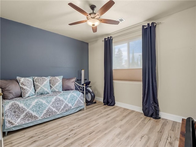 bedroom featuring visible vents, ceiling fan, baseboards, and wood finished floors