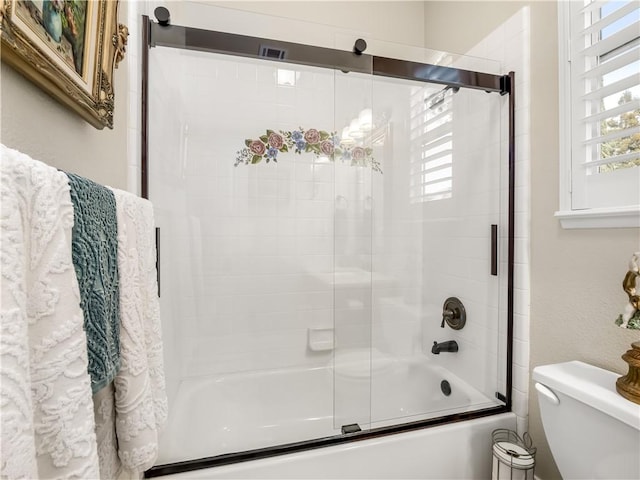 full bath featuring combined bath / shower with glass door and toilet