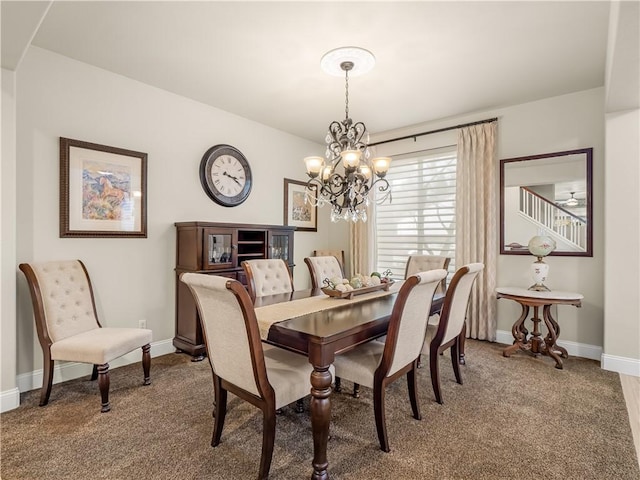 dining space with carpet floors, a chandelier, and baseboards