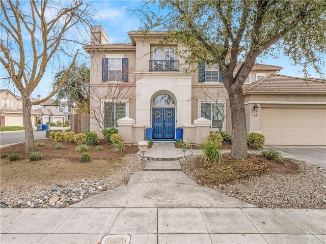 2705 E Ryan Ln, Fresno, CA 93720 - view of front of home with a chimney, stucco siding, a garage, and a balcony