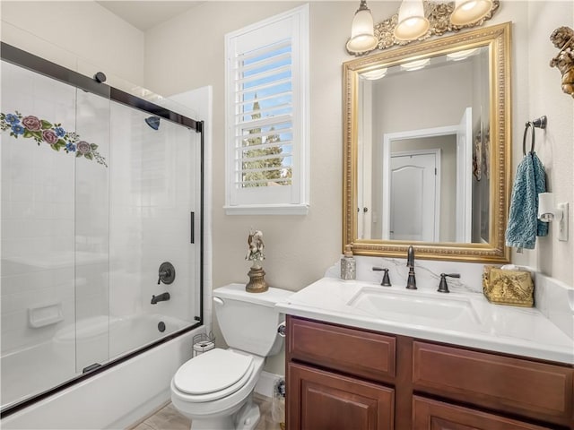 bathroom featuring vanity, toilet, and bath / shower combo with glass door