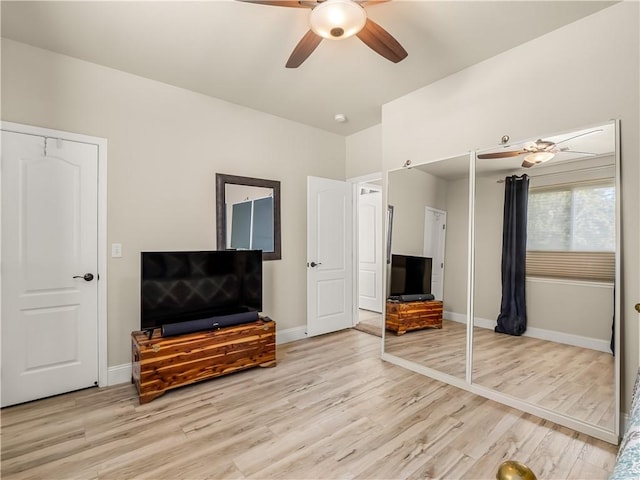 living area with a ceiling fan, baseboards, and light wood finished floors