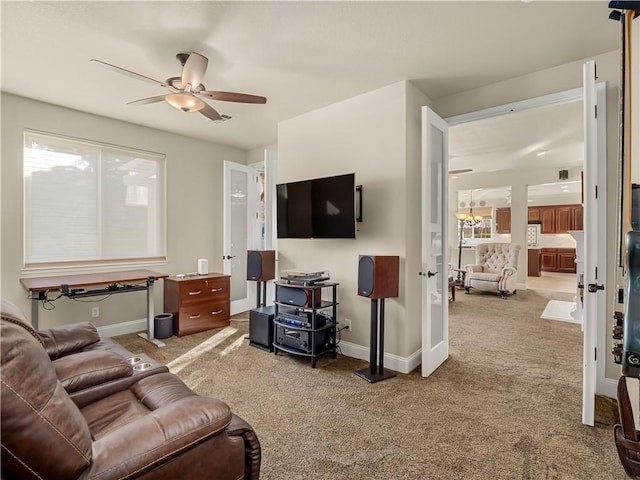 living room with carpet floors, a ceiling fan, and baseboards