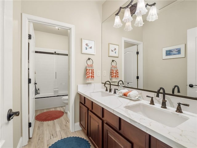 2705 E Ryan Ln, Fresno, CA 93720 - full bath featuring a chandelier, toilet, wood finished floors, double vanity, and shower / bath combination with glass door