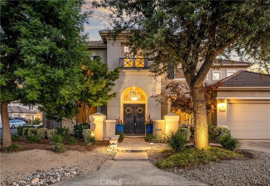 2705 E Ryan Ln, Fresno, CA 93720 - view of front of home with an attached garage, stucco siding, french doors, a balcony, and a tile roof