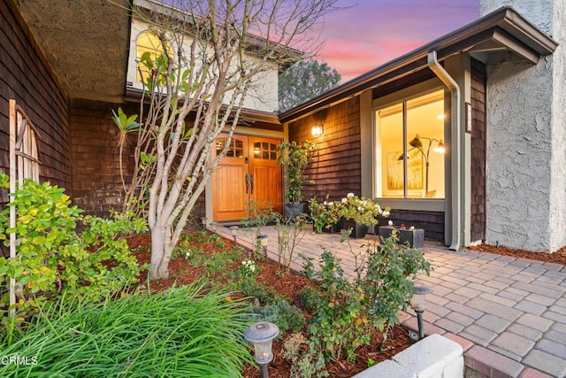 exterior entry at dusk featuring stucco siding