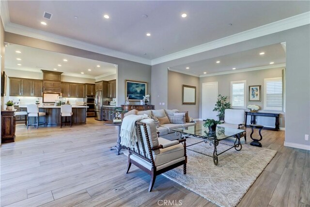 living room with baseboards, visible vents, light wood-style floors, and recessed lighting