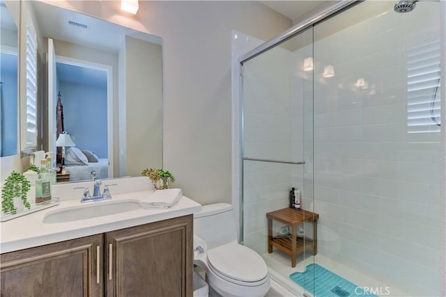 ensuite bathroom featuring connected bathroom, a tile shower, toilet, vanity, and visible vents