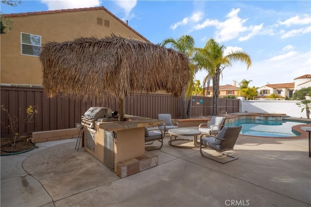 view of patio / terrace with a fenced in pool, a grill, exterior kitchen, a residential view, and a fenced backyard