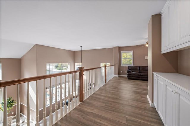 hallway with dark wood-style flooring and baseboards