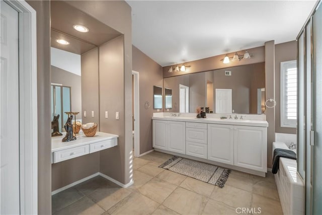 bathroom with double vanity, a sink, and baseboards