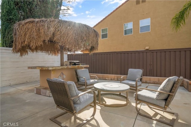 view of patio with outdoor dry bar, outdoor lounge area, and fence