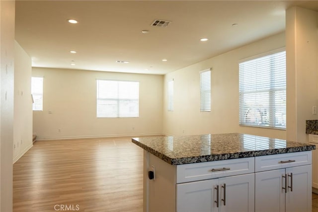 kitchen featuring visible vents, white cabinets, open floor plan, light wood-style floors, and recessed lighting