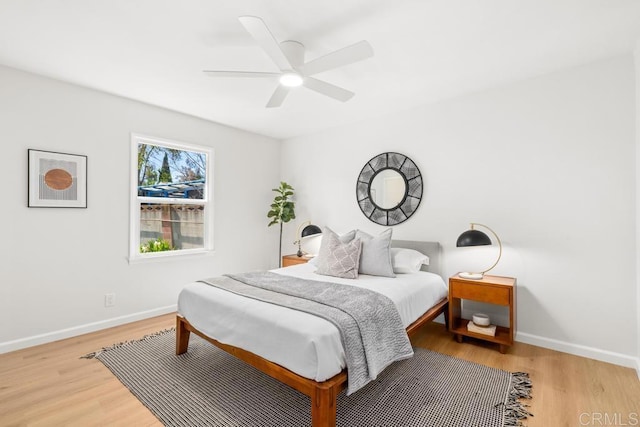 bedroom featuring light wood-type flooring, a ceiling fan, and baseboards