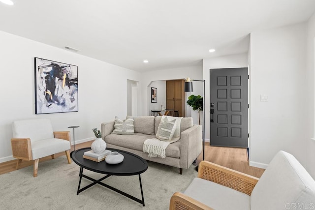 living area with baseboards, recessed lighting, visible vents, and light wood-style floors