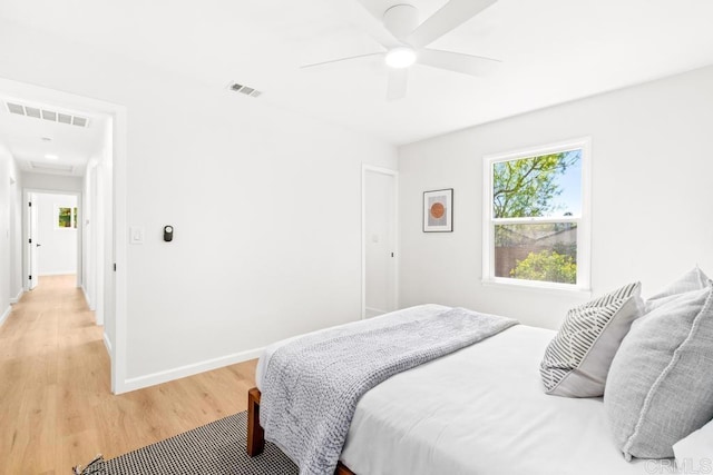 bedroom with baseboards, ceiling fan, visible vents, and light wood-style floors