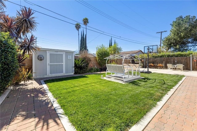 view of yard with a patio area, a fenced backyard, an outdoor structure, and a storage shed