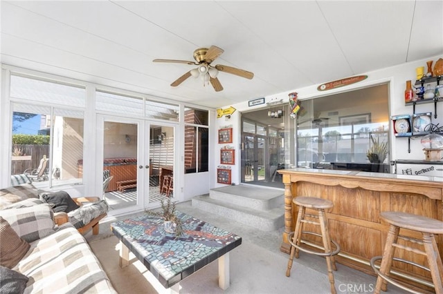 sunroom with ceiling fan and a dry bar