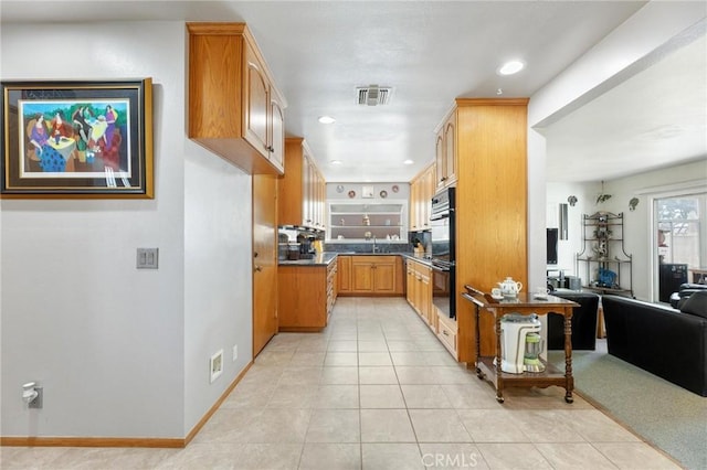 kitchen with dobule oven black, baseboards, visible vents, dark countertops, and light tile patterned flooring