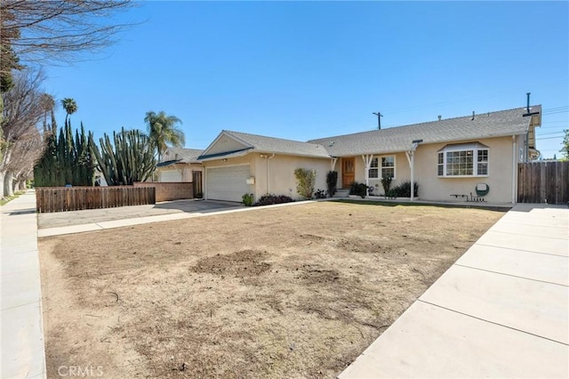 single story home featuring a garage, fence, concrete driveway, and stucco siding